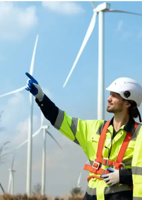 Consultor ambiental y asesora ambiental inspeccionan turbinas eólicas en terreno como parte de una consultoría ambiental para SEIA, evaluando impactos y medidas de mitigación