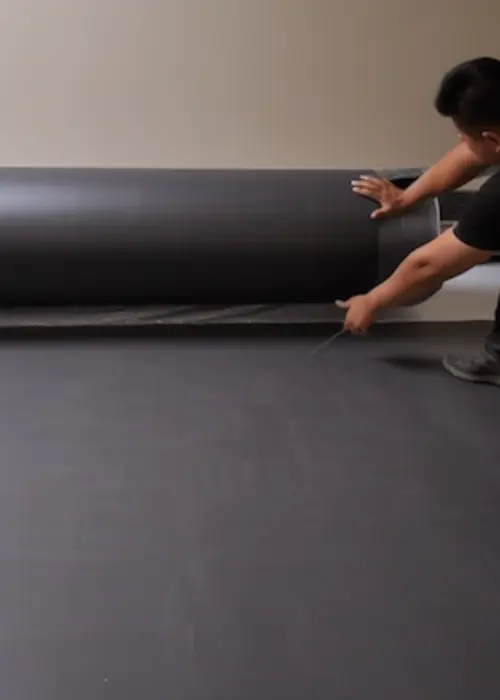 membrana acústica para paredes tipo vinilo de alta densidad (MLV) para su corte e instalación, asegurando solapes sellados y mejor aislamiento del recint